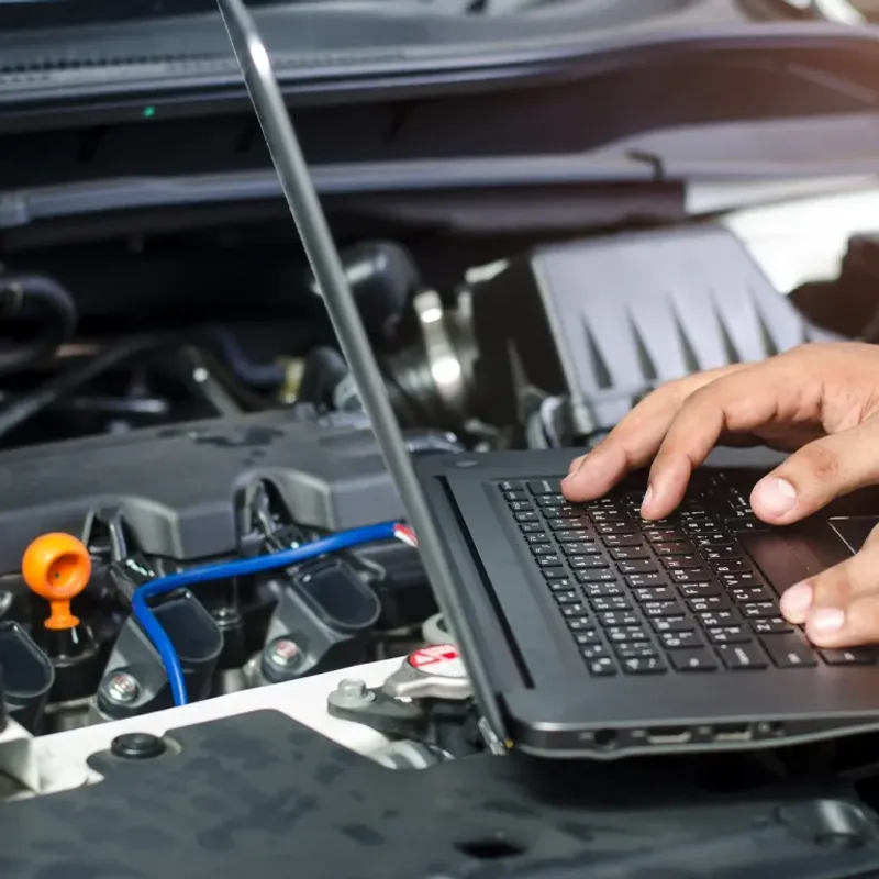 Close-up of laptop during ECU remapping process with engine bay in the background